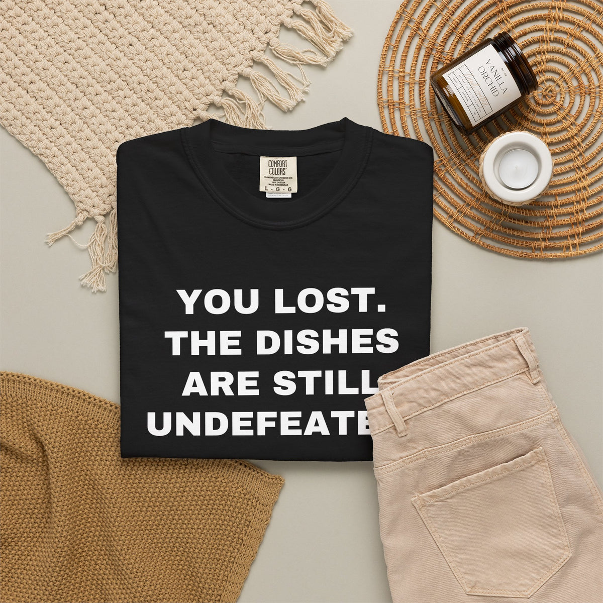 Black shirt flat lay showing the front rivalry slogan.